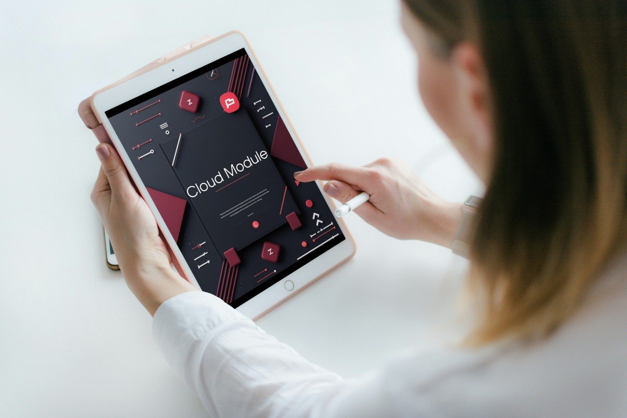 Person using a tablet with an app interface on a white surface